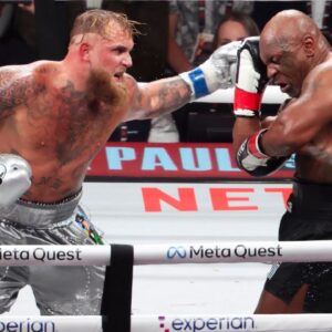 Mike Tyson (black gloves) fights Jake Paul (silver gloves) at AT&T Stadium.