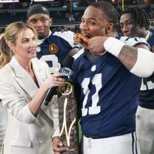 Nov 28, 2024; Arlington, Texas, USA; Dallas Cowboys linebacker Micah Parsons (11) stands with Madden Thanksgiving MVP trophy after defeating the New York Giants at AT&T Stadium.