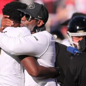 Colorado football coach Deion Sanders hugs his son, Shedeur Sanders, before facing Texas Tech in a Big 12 football game