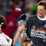 ampa Bay Buccaneers quarterback Tom Brady (12) and son John Jack Brady celebrate with the Vince Lombardi Trophy after beating the Kansas City Chiefs in Super Bowl LV at Raymond James Stadium.