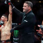 Brandon Moreno (red gloves) celebrates after defeating Amir Albazi (blue gloves) in a flyweight bout during UFC Fight Night at Rogers Place.