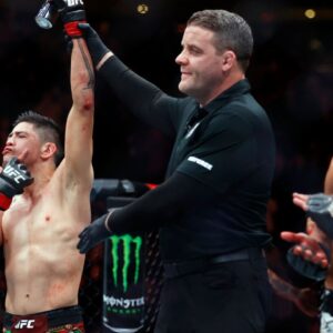 Brandon Moreno (red gloves) celebrates after defeating Amir Albazi (blue gloves) in a flyweight bout during UFC Fight Night at Rogers Place.