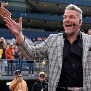 ESPN College Game Day's Pat McAfee high-fives fans as he takes the field before the game between Michigan and Texas at Michigan Stadium in Ann Arbor on Saturday, September 7, 2024.