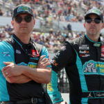 NASCAR Cup Series driver Denny Hamlin (right) stands with his crew chief Chris Gabehart (left) on pit road prior to The Great American Getaway 400 at Pocono Raceway.