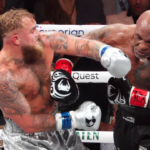 Mike Tyson (black gloves) fights Jake Paul (silver gloves) at AT&T Stadium.