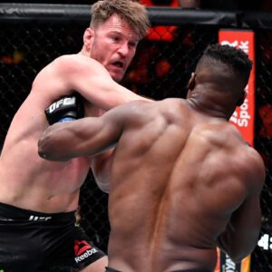 Stipe Miocic punches Francis Ngannou of Cameroon in their UFC heavyweight championship fight during the UFC 260 event at UFC APEX on March 27, 2021 in Las Vegas, Nevada.