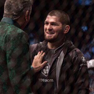 Khabib Nurmagomedov (right) greets Bruce Buffer (left) after the fight between Abubakar Nurmagomedov (red gloves) and Gadzhi Omargadzhiev (blue gloves) during UFC 280 at Etihad Arena.