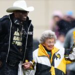 Colorado Buffaloes head coach holds the hand of fan Peggy Coppom before the start of the spring game at Folsom Filed.