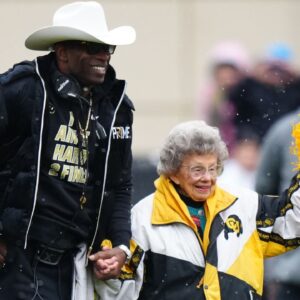 Colorado Buffaloes head coach holds the hand of fan Peggy Coppom before the start of the spring game at Folsom Filed.