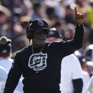 Colorado Buffaloes head coach Deion Sanders calls in a play in the first quarter against the Utah Utes at Folsom Field.