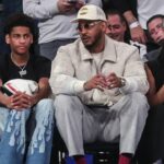 Former NBA player Carmelo Anthony (r) sits with his son Kiyan Anthony (l) at the game between the Boston Celtics and the New York Knicks at Madison Square Garden.