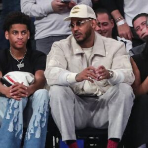 Former NBA player Carmelo Anthony (r) sits with his son Kiyan Anthony (l) at the game between the Boston Celtics and the New York Knicks at Madison Square Garden.