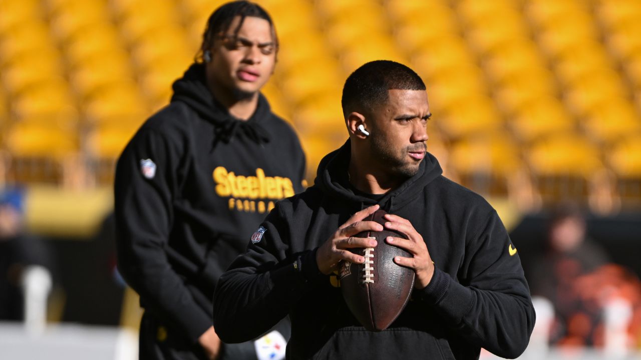Pittsburgh Steelers quarterback Russell Wilson throws the ball as Justin Fields looks during warm ups for a game against the Cleveland Browns at Acrisure Stadium.