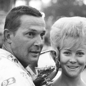 Driver Jim Paschal, left, accepts the trophy from Jenny Smith, Miss Fairgrounds Speedway, after winning the Nashville 400 at the Fairgrounds Speedway Aug. 4, 1963. Paschal won his third straight on the track in the rain-shortened NASCAR late model race before 12,875 fans. Auto Racingt In 1963