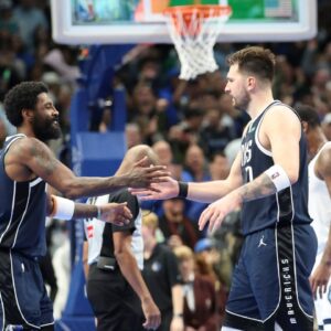 Dallas Mavericks guard Kyrie Irving (11) celebrates with Dallas Mavericks guard Luka Doncic (77) during the fourth quarter against the Memphis Grizzlies at American Airlines Center.