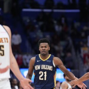 New Orleans Pelicans center Yves Missi (21) celebrates a basket with New Orleans Pelicans guard CJ McCollum (3) as Denver Nuggets center Nikola Jokic (15) reacts during overtime at Smoothie King Center.
