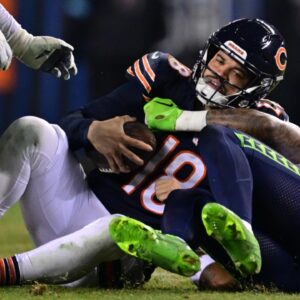 Dec 26, 2024; Chicago, Illinois, USA; Chicago Bears quarterback Caleb Williams (18) is sacked by Seattle Seahawks defensive back Rayshawn Jenkins (2) during the fourth quarter at Soldier Field.