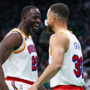 Golden State Warriors forward Draymond Green (23) and Golden State Warriors guard Stephen Curry (30) celebrate during the first half against the Boston Celtics at TD Garden.