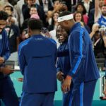 United States centre Joel Embiid (11) and guard Anthony Edwards (5) and guard Jrue Holiday (12) and centre Bam Adebayo (13) and centre Anthony Davis (14) celebrate after defeating France in the men's basketball gold medal game during the Paris 2024 Olympic Summer Games at Accor Arena.