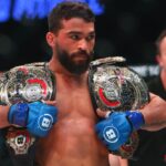 Patricio Freire (blue gloves) celebrates with his championship belts after defeating Michael Chandler (red gloves) during Bellator 221 at Allstate Arena.
