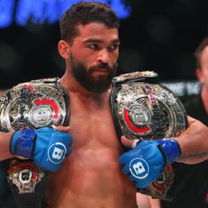 Patricio Freire (blue gloves) celebrates with his championship belts after defeating Michael Chandler (red gloves) during Bellator 221 at Allstate Arena.