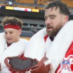 Kansas City Chiefs quarterback Patrick Mahomes (left) and tight end Travis Kelce (right) open their Netflix Christmas GameDay cake after the Chiefs defeated the Pittsburgh Steelers at Acrisure Stadium.