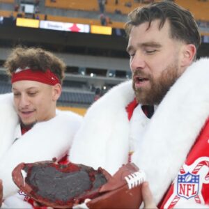 Kansas City Chiefs quarterback Patrick Mahomes (left) and tight end Travis Kelce (right) open their Netflix Christmas GameDay cake after the Chiefs defeated the Pittsburgh Steelers at Acrisure Stadium.