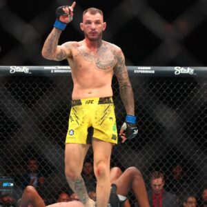 Renato Moicano (blue gloves) reacts after defeating Jalin Turner (red gloves) during UFC 300 at T-Mobile Arena.