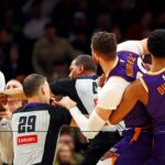 Dallas Mavericks forward Naji Marshall (13) punches Phoenix Suns center Jusuf Nurkic (20) during the third quarter at Footprint Center.