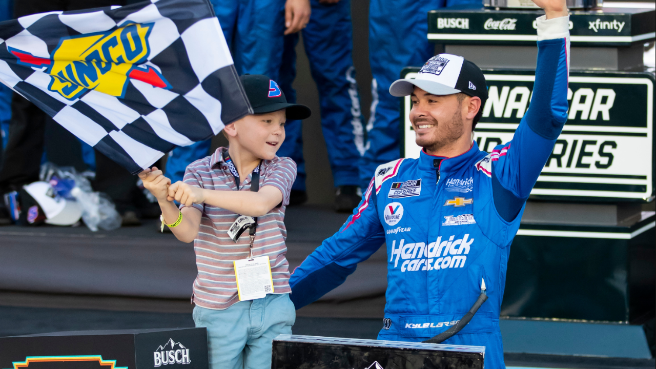 Nov 7, 2021; Avondale, Arizona, USA; NASCAR Cup Series driver Kyle Larson (5) celebrates with son Owen Larson after winning the 2021 NASCAR Cup Series Championship at Phoenix Raceway. Mandatory Credit: Mark J. Rebilas-Imagn Images