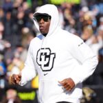 Colorado Buffaloes head coach Deion Sanders runs onto the field before the game against the Oklahoma State Cowboys at Folsom Field.