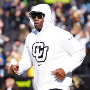 Colorado Buffaloes head coach Deion Sanders runs onto the field before the game against the Oklahoma State Cowboys at Folsom Field.