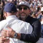 California Golden Bears former quarterback Aaron Rodgers (center right) hugs former head coach Jeff Tedford (left) before the start of the second quarter against the Stanford Cardinal at California Memorial Stadium.