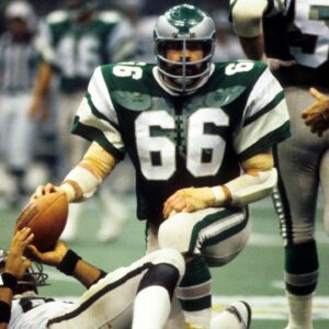 Philadelphia Eagles linebacker Bill Bergey (66) kneels over Oakland Raiders tight end Raymond Chester (88) in Super Bowl XV at the Superdome. The Raiders defeated the Eagles 27-10.