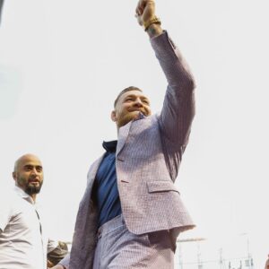 MMA fighter Conor McGregor waves to fans as he walks on the field before the game between the Chicago Cubs and the Minnesota Twins at Wrigley Field.