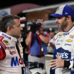 NASCAR Sprint Cup Series driver Tony Stewart (L) talks with NASCAR Sprint Cup Series driver Jimmie Johnson (R) during qualifying for the Ford Ecoboost 400 at Homestead-Miami Speedway.