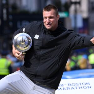 Former New England Patriots tight end and honorary Grand Marshall Rob Gronkowski poses for photos on the finish line of the 2024 Boston Marathon.