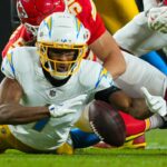 Dec 8, 2024; Kansas City, Missouri, USA; Los Angeles Chargers wide receiver Quentin Johnston (1) recovers a fumble against Kansas City Chiefs defensive end George Karlaftis (56) during the first half at GEHA Field at Arrowhead Stadium.