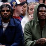 University of Colorado Buffaloes football players Shedeur Sanders (L) and Travis Hunter (R) watch during the third period between the Denver Nuggets and the Los Angeles Lakers at Ball Arena.
