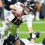 Dec 16, 2024; Paradise, Nevada, USA; Atlanta Falcons quarterback Kirk Cousins (18) is tripped up by Las Vegas Raiders defensive tackle Jonah Laulu (96) during the second quarter at Allegiant Stadium.