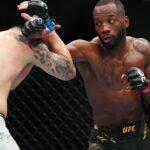 Leon Edwards (red gloves) fights Colby Covington (blue gloves) during UFC 296 at T-Mobile Arena.