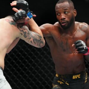 Leon Edwards (red gloves) fights Colby Covington (blue gloves) during UFC 296 at T-Mobile Arena.