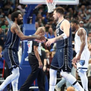 Dallas Mavericks guard Kyrie Irving (11) celebrates with Dallas Mavericks guard Luka Doncic (77) during the fourth quarter against the Memphis Grizzlies at American Airlines Center.