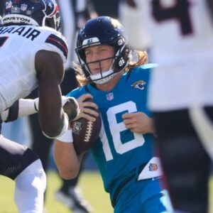 Jacksonville Jaguars quarterback Trevor Lawrence (16) slides for a down as Houston Texans linebacker Azeez Al-Shaair (0) makes a late hit during the second quarter of an NFL football matchup Sunday, Dec. 1, 2024 at EverBank Stadium in Jacksonville, Fla.