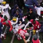 Players scrum at midfield following Saturday’s NCAA Division I football game between the Ohio State Buckeyes and the Michigan Wolverines.