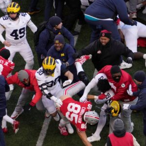 Players scrum at midfield following Saturday’s NCAA Division I football game between the Ohio State Buckeyes and the Michigan Wolverines.
