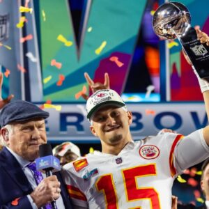 Kansas City Chiefs quarterback Patrick Mahomes (15) celebrates with the Vince Lombardi Trophy alongside Fox host Terry Bradshaw after defeating the Philadelphia Eagles during Super Bowl LVII at State Farm Stadium.