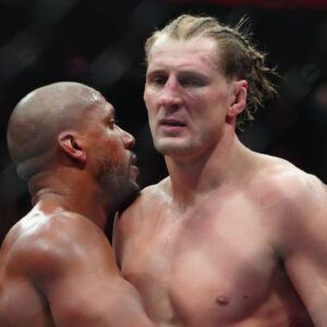 Ciryl Gane (red gloves) hugs Alexander Volkov (blues gloves) after their fight at T-Mobile Arena.