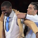 Aug 3, 2018; Canton, OH, USA; Minnesota Vikings, Oakland Raiders, New England Patriots, Tennessee Titans and San Francisco 49ers former receiver Randy Moss receives gold jacket from presenter and son Thaddeus Moss during the Enshrinee's gold jacket dinner at the Canton Civic Center.