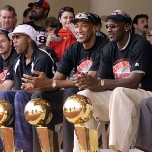 Chicago Bulls with their six championship trophies. Left to right in the front row are Luc Longley, Toni Kukoc, Ron Harper, Dennis Rodman (leaning back), Scottie Pippen, Michael Jordan and Chicago Mayor Richard Daley at a championship rally at Grant Park in Chicago.